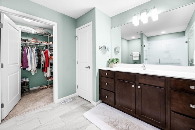 bathroom featuring walk in shower and vanity