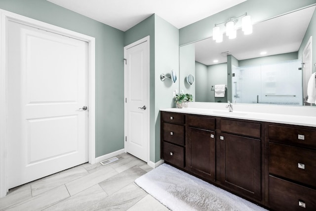 bathroom with vanity and a shower with door