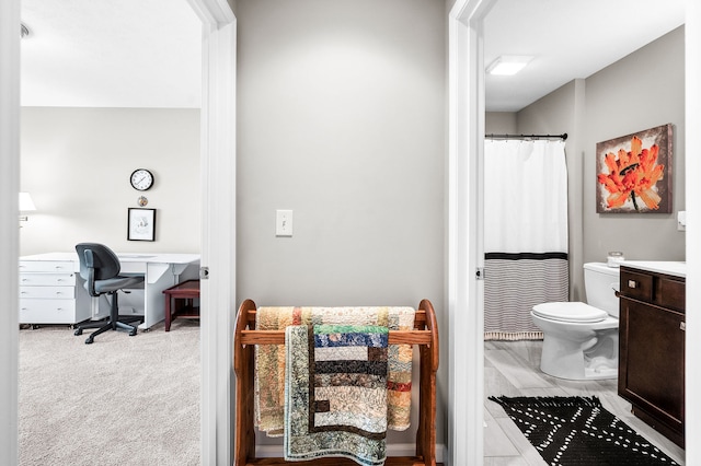 bathroom featuring vanity, walk in shower, and toilet