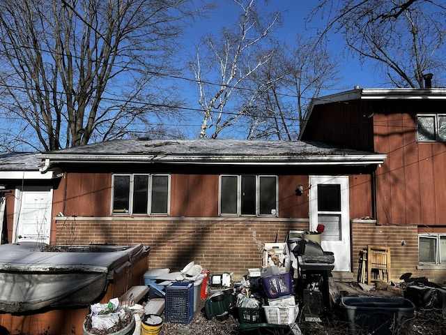 rear view of house featuring a hot tub