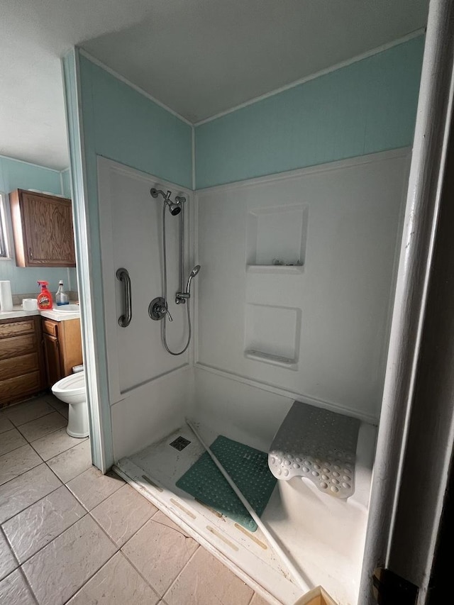 bathroom with vanity, tile patterned flooring, toilet, and a shower