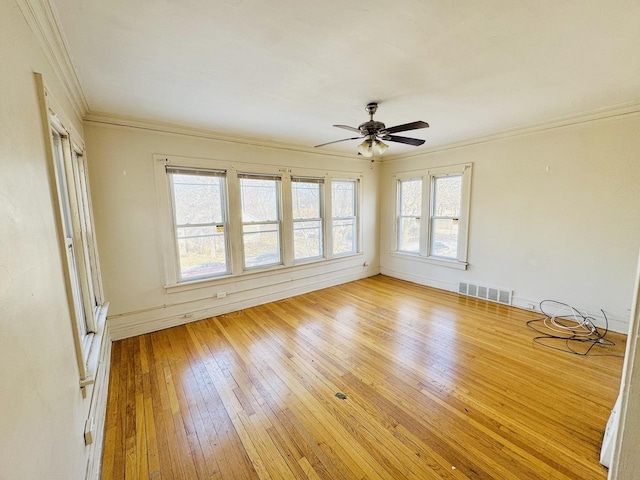 empty room featuring crown molding, light hardwood / wood-style flooring, and ceiling fan