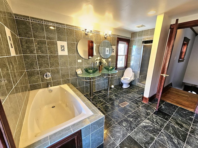 full bathroom featuring plus walk in shower, sink, tile walls, and toilet