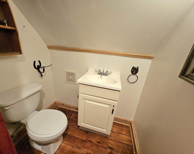 bathroom with vanity, lofted ceiling, hardwood / wood-style floors, and toilet