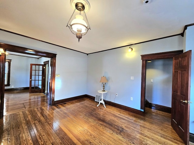 empty room featuring crown molding and wood-type flooring