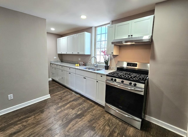 kitchen featuring light stone countertops, sink, stainless steel range with gas stovetop, and white cabinets