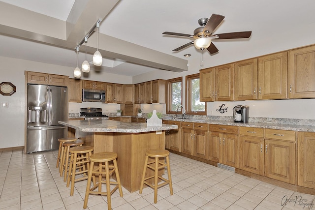 kitchen with a breakfast bar, pendant lighting, sink, a center island, and stainless steel appliances