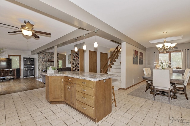 kitchen featuring pendant lighting, a center island, light stone countertops, and light tile patterned floors