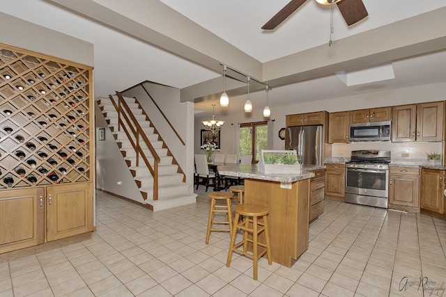 kitchen featuring a breakfast bar, light stone counters, decorative light fixtures, a kitchen island, and stainless steel appliances