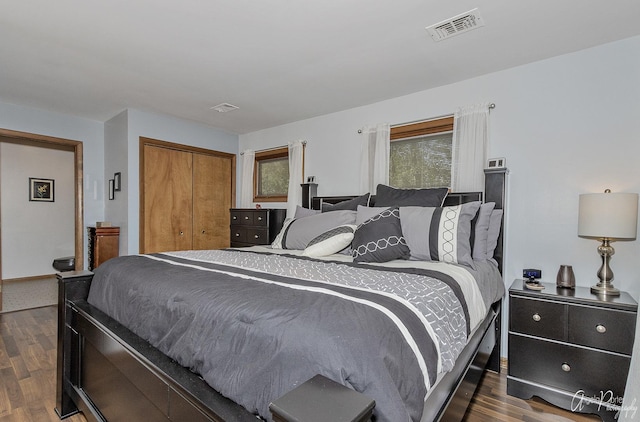 bedroom with dark hardwood / wood-style floors and a closet