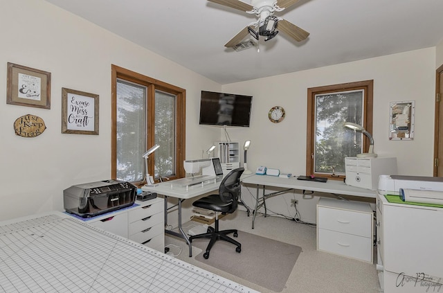 carpeted office space featuring ceiling fan