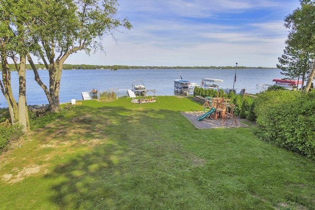 view of yard featuring a water view, a dock, and a playground