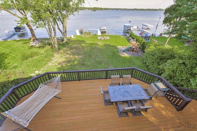 deck featuring a lawn, a playground, and a water view