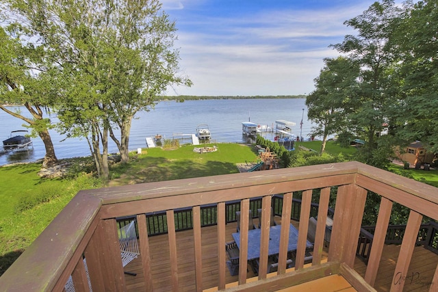 deck with a lawn and a water view