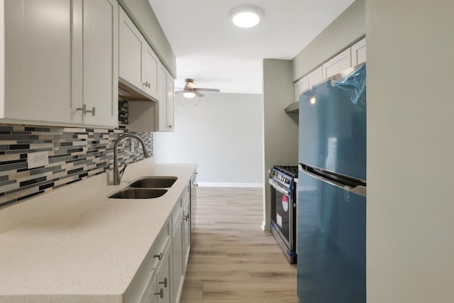 kitchen with backsplash, stainless steel appliances, sink, and white cabinets