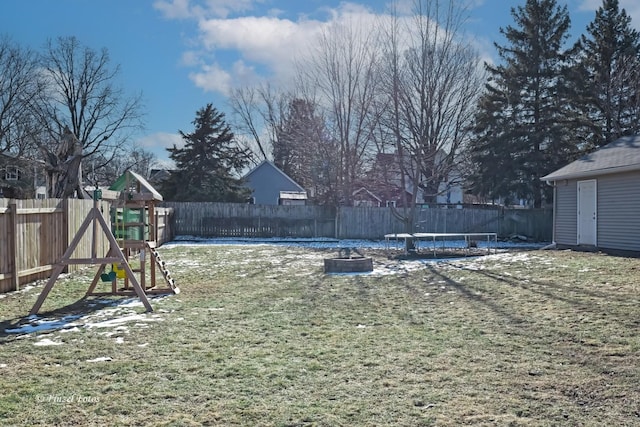 view of yard featuring a playground and an outdoor fire pit