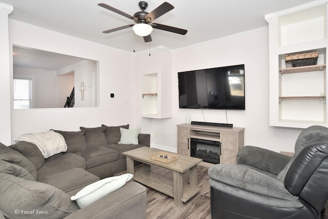 living room featuring crown molding, ceiling fan, and light wood-type flooring