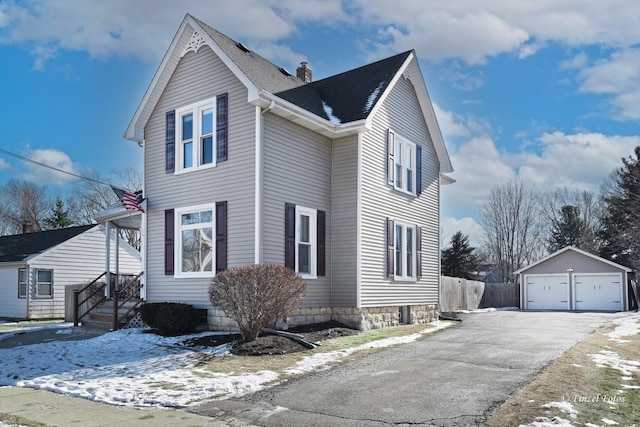 view of snowy exterior with an outbuilding and a garage