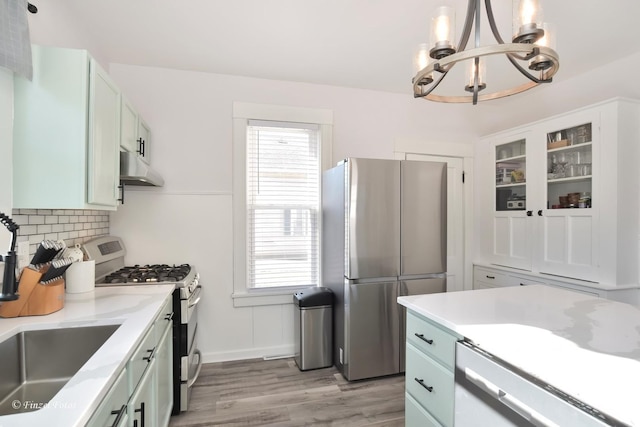 kitchen featuring hanging light fixtures, light hardwood / wood-style flooring, stainless steel appliances, and white cabinets