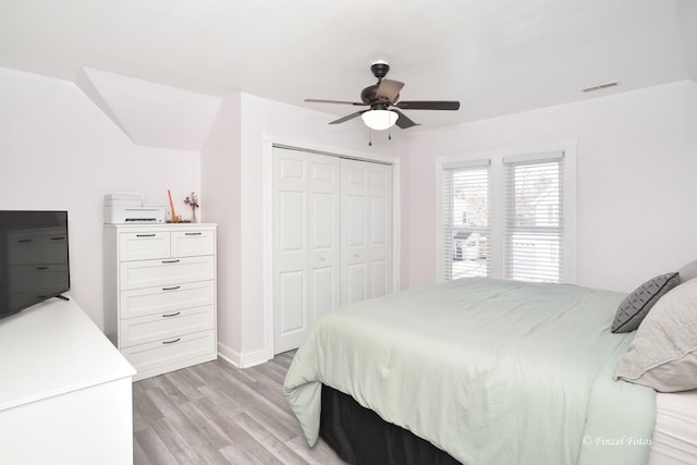 bedroom with ceiling fan, light hardwood / wood-style floors, and a closet