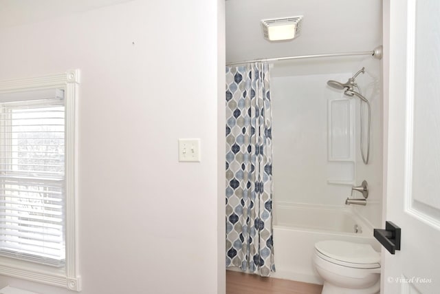 bathroom featuring toilet, wood-type flooring, shower / bath combo, and a wealth of natural light