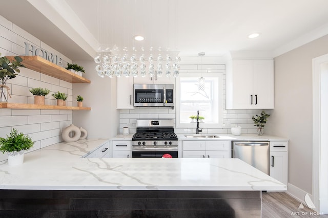 kitchen featuring light stone counters, appliances with stainless steel finishes, decorative backsplash, and white cabinets