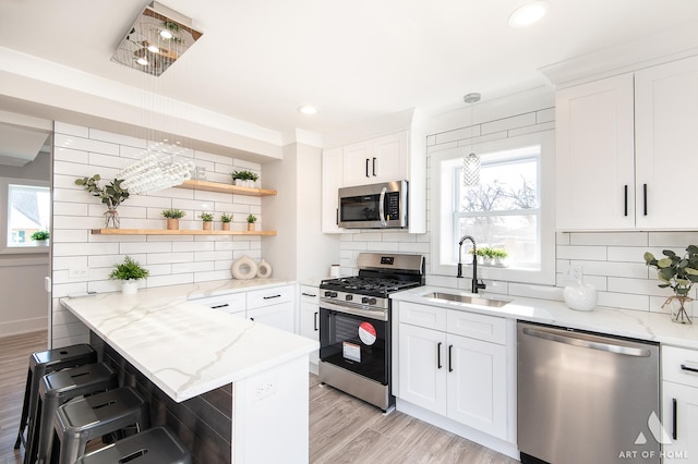 kitchen featuring stainless steel appliances, sink, and white cabinets