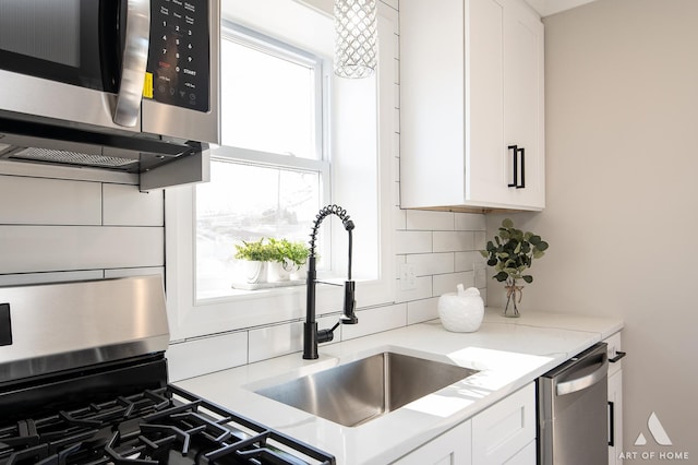 kitchen with tasteful backsplash, light stone countertops, white cabinets, and stainless steel appliances