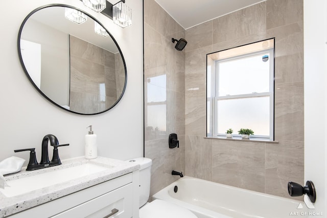 full bathroom featuring vanity, tiled shower / bath combo, and toilet