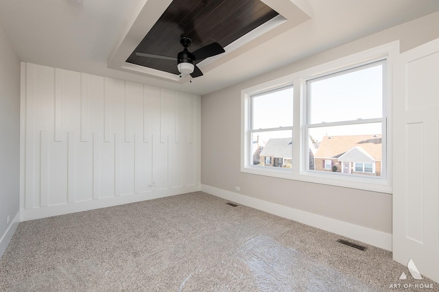 carpeted empty room featuring a raised ceiling