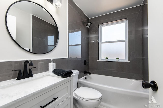 full bathroom with tile walls, vanity, toilet, and tiled shower / bath