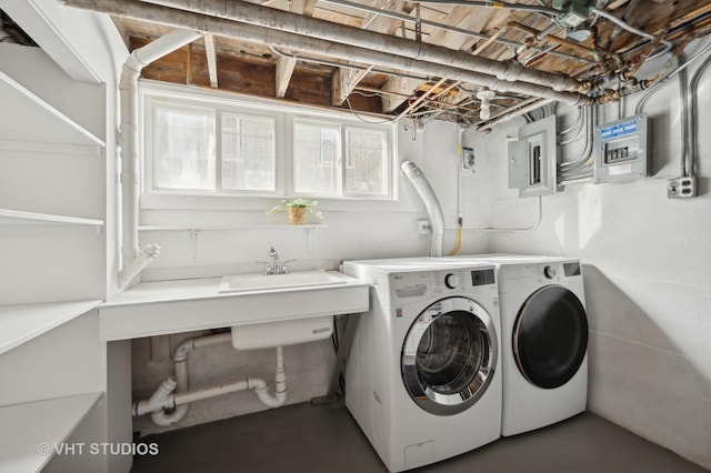 clothes washing area with washing machine and dryer and electric panel