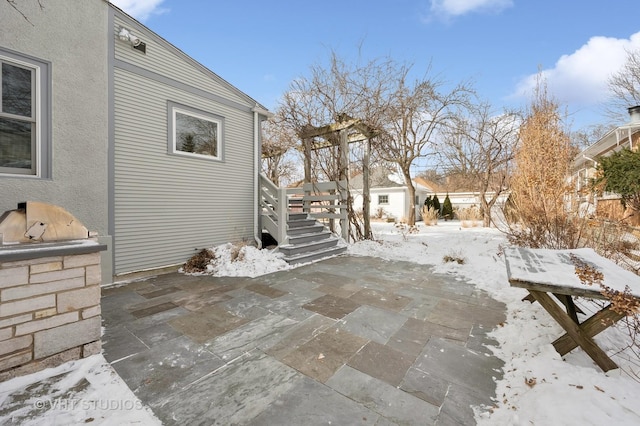 snow covered patio with an outdoor kitchen