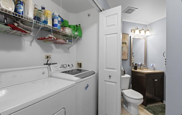 washroom with light tile patterned floors, laundry area, separate washer and dryer, a sink, and visible vents