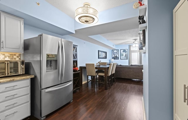 kitchen featuring ceiling fan, a textured ceiling, backsplash, stainless steel fridge with ice dispenser, and dark wood finished floors