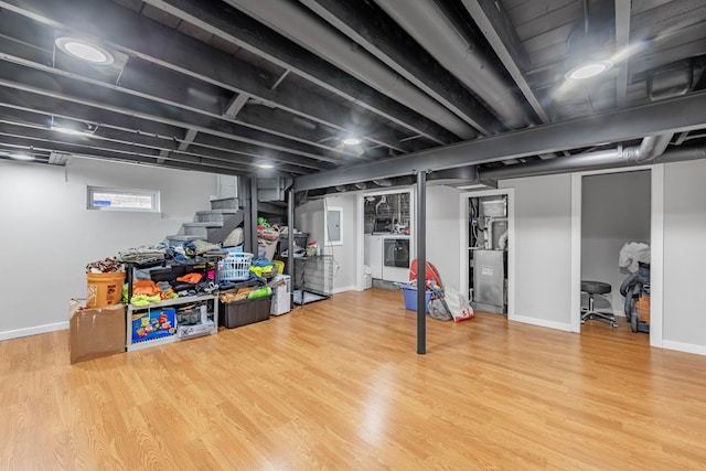 basement with independent washer and dryer and wood-type flooring