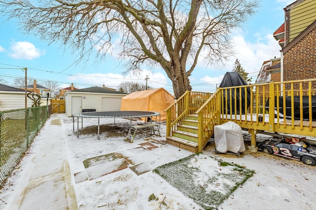 exterior space featuring a trampoline, a wooden deck, and a storage unit