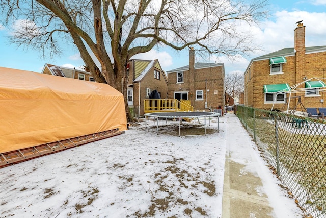 yard covered in snow with a trampoline