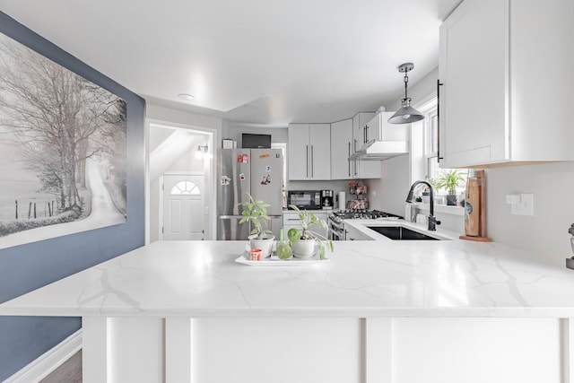 kitchen featuring sink, white cabinetry, stainless steel appliances, decorative light fixtures, and kitchen peninsula