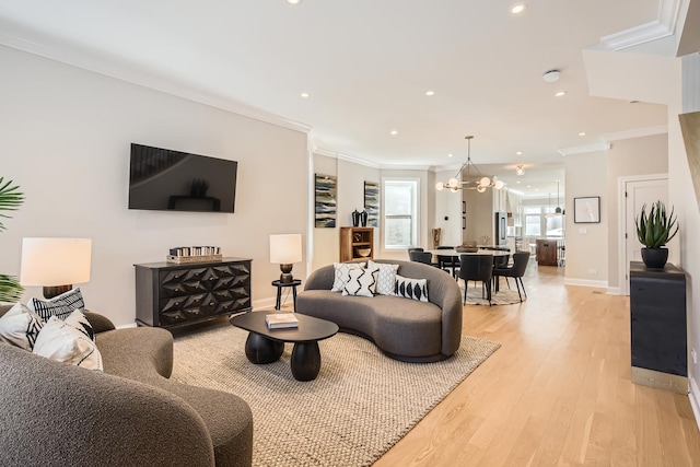 living area featuring baseboards, crown molding, light wood-style floors, a chandelier, and recessed lighting