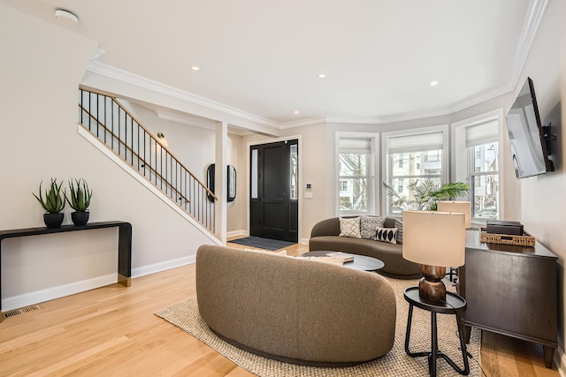 living room with ornamental molding, stairway, wood finished floors, and visible vents