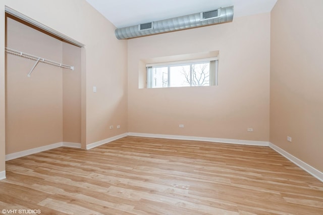 unfurnished bedroom with light wood-style flooring, a closet, visible vents, and baseboards