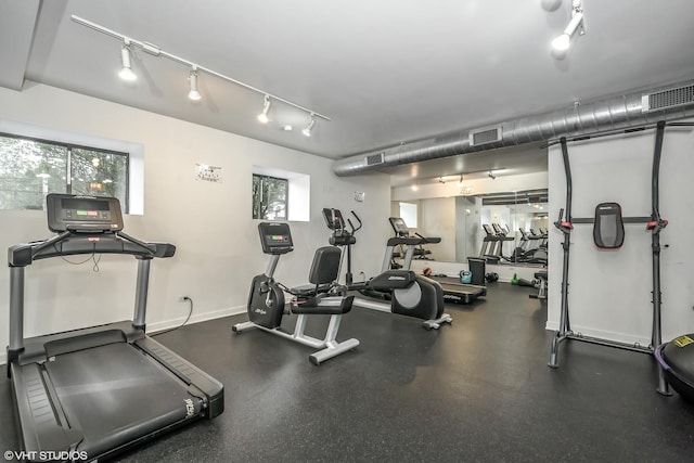 gym featuring baseboards, visible vents, and track lighting