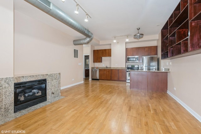 kitchen with light wood finished floors, stainless steel appliances, light countertops, visible vents, and modern cabinets