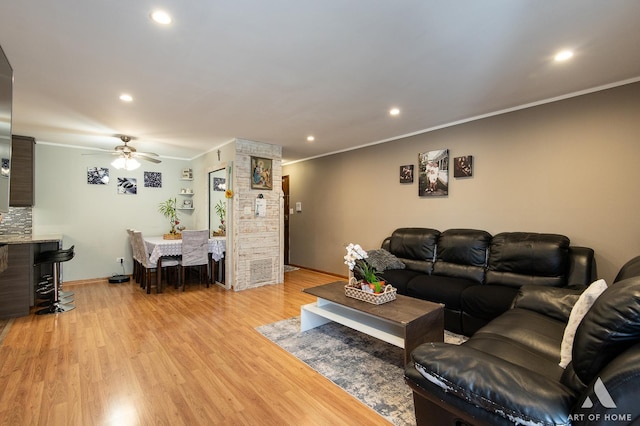 living room featuring crown molding, ceiling fan, and light hardwood / wood-style floors