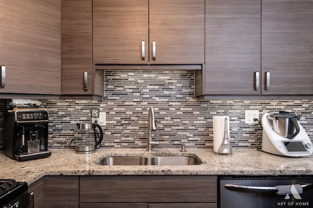 kitchen with sink, stainless steel dishwasher, light stone counters, and decorative backsplash