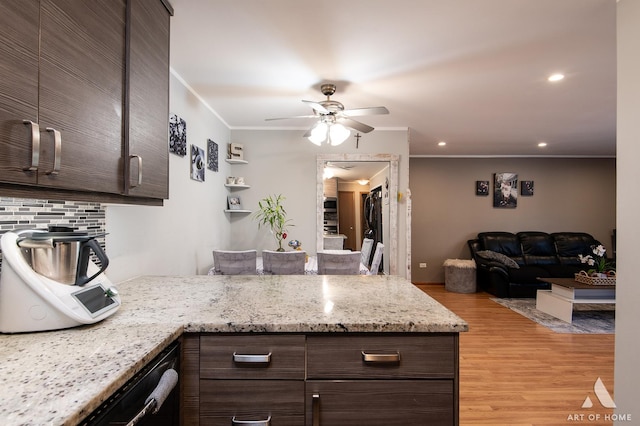 kitchen with ceiling fan, light stone counters, tasteful backsplash, dark brown cabinetry, and light hardwood / wood-style floors