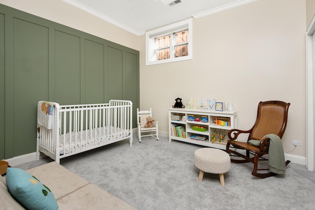 bedroom featuring crown molding, carpet flooring, and a crib