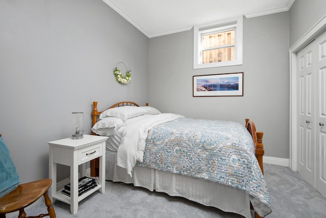 carpeted bedroom with ornamental molding and a closet