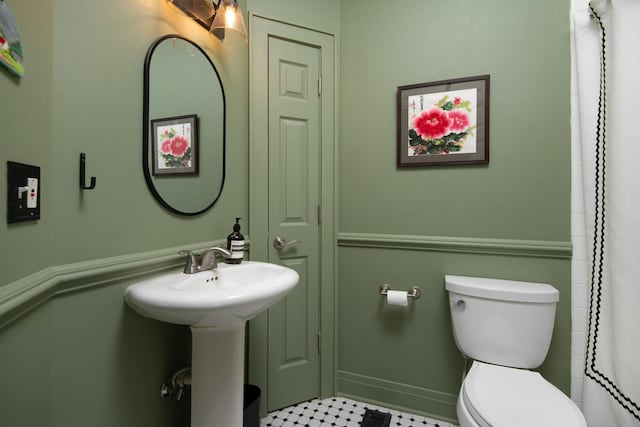 bathroom with a shower with curtain, sink, and toilet